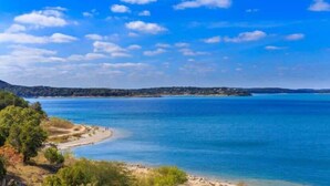 A coastal landscape with a clear sky, calm sea, and a sandy beach. - 3/2, Private hot tub, fireplace, firepit (Blanco)