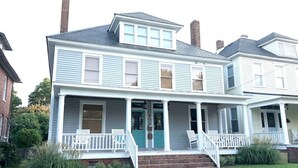 A two-story house with a front porch, a garage, and a small front yard. - Salt Box II, One Block to the Beach (Cape Charles)