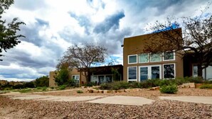 A modern building with a flat roof, large windows, and a landscaped garden with gravel paths.