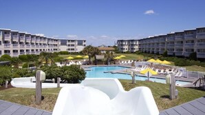 Ein Resort mit Swimmingpool, Liegestühlen und einer Rutsche.
