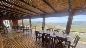 A restaurant with wooden flooring and tables set for dining, overlooking a scenic landscape. - Santo Domingo Lodge (Santo Domingo)
