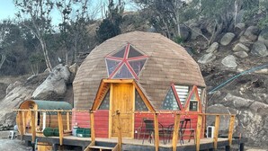 A dome-shaped wooden structure with a star window, wooden deck, and a staircase leading to the entrance. - Santo Domingo Lodge (Santo Domingo)