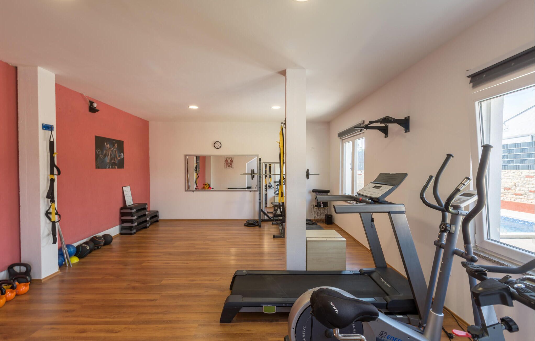 A gym with treadmills, a stationary bike, and various weights.