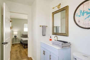 A bathroom with a white vanity, a sink, a mirror, and a map on the wall. - 4/3, hot tub, Lake Views, private lot (Canyon Lake)