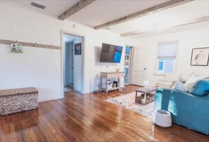Relax in this open-plan living space with a sofa, desk, and flat-screen TV.