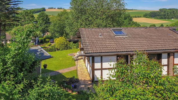A traditional house with a tiled roof, surrounded by lush greenery and a well-maintained lawn. - Awesome home in Meschede with WiFi (Meschede)