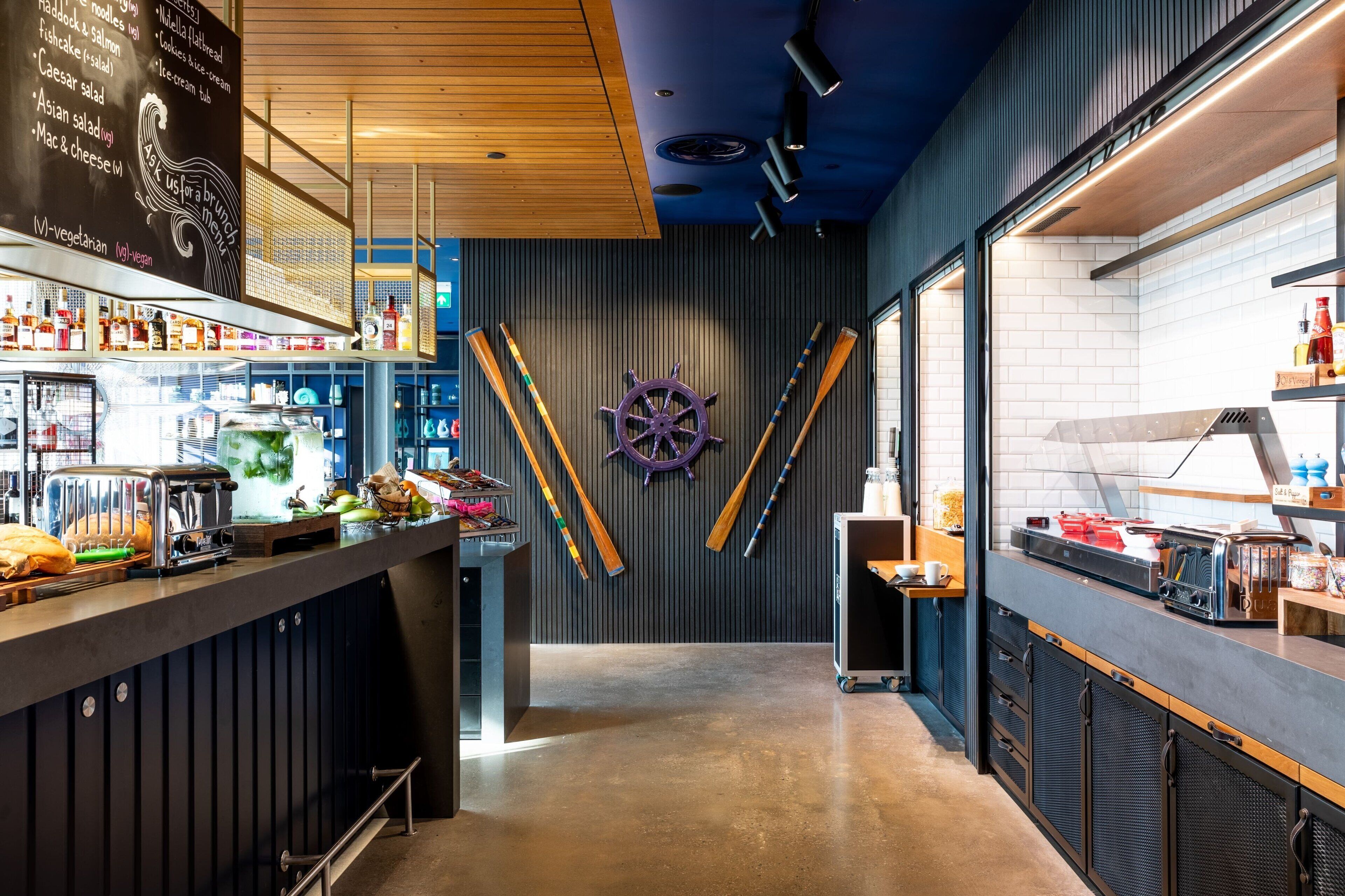 Een bar met houten plafond, een decoratieve scheepsschroef en verschillende barbenodigdheden en flessen.