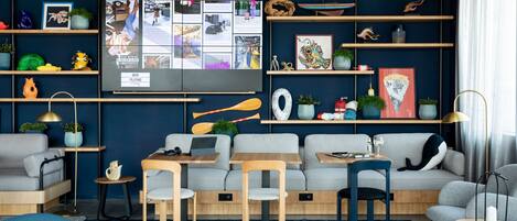 A modern living room with a large TV, sofas, chairs, and a coffee table.