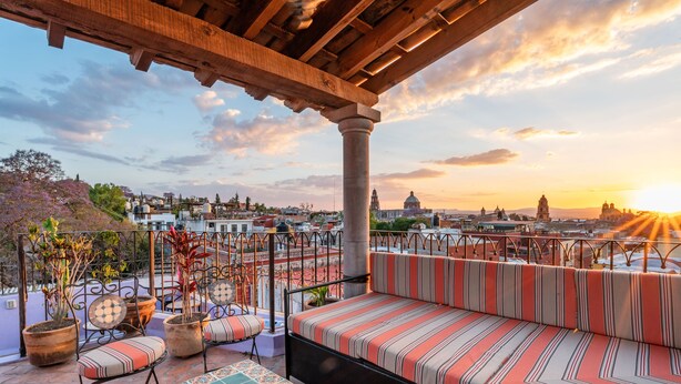 A rooftop terrace with a wooden pergola, a striped sofa, and potted plants. - Casa Esperanza, 2BR Designer Charm + Rooftop Views (San Miguel de Allende)
