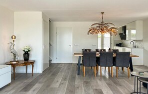 Enjoy meals in this stylish dining area with a central table and six chairs, surrounded by a unique chandelier and decorative accents.