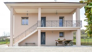 Un bâtiment à deux étages doté d’un balcon, d’un escalier et d’une charrette.