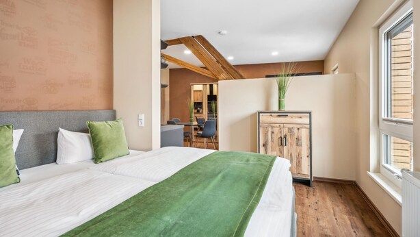 Une chambre d’hôtel avec un grand lit, une armoire en bois et une vue sur l’extérieur.
