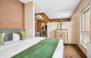Une chambre d’hôtel avec un grand lit, une armoire en bois et une vue sur l’extérieur.
