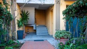 A narrow pathway leading to a set of stairs with a small table and potted plants on either side. - 2 bedroom gorgeous apartment in San Costanzo (San Costanzo)