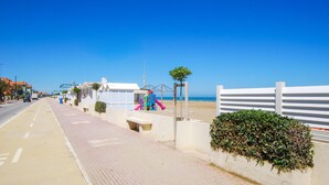 A coastal road with a pedestrian walkway, beachside structures, and a white fence. - 2 bedroom gorgeous apartment in San Costanzo (San Costanzo)