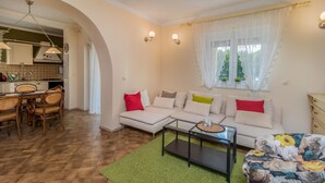 Ein Wohnzimmer mit einer Couch, einem Couchtisch und einem Essbereich mit Stühlen und einem Tisch.