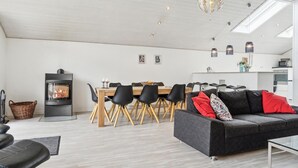 A modern living room with a fireplace, dining area, and kitchen.
