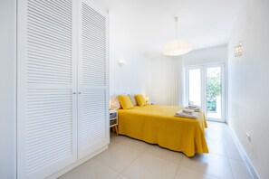 Une chambre à coucher avec un lit, une table de chevet et une vue sur l’extérieur.