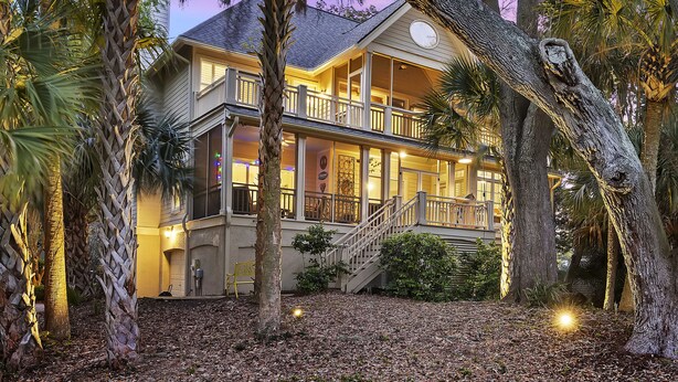 A two-story house with a balcony, surrounded by trees and a well-maintained garden. - 23 Ocean Green-  Comm. Pool, 4 Bed, Golf Views, Walk to Beach!! (Kiawah Island)