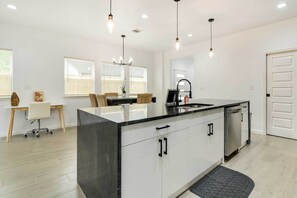 Enjoy meals in this well-equipped kitchen with a central island, pendant lights, and a dining area for four.