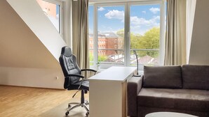 Een moderne kantoorruimte met een bureau, bureaustoel en een bank.