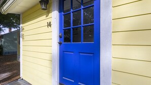 Ein gelbes Haus mit einer blauen Tür und der Hausnummer 14.