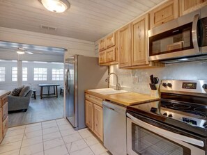 A kitchen with wooden cabinets, stainless steel appliances, and a view to a dining area.