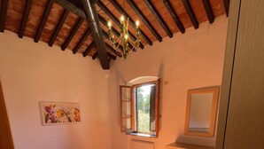 A bedroom with a bed, a window with shutters, a mirror, and a chandelier. - Maison Antoinette - Lavender (Toscana)