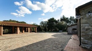 A courtyard with stone flooring, a covered pergola, and a stone building with a tiled roof. - Maison Antoinette - Lavender (Toscana)