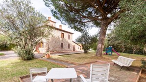 A stone building with a garden patio, outdoor seating, and a playground. - Maison Antoinette - Lavender (Toscana)
