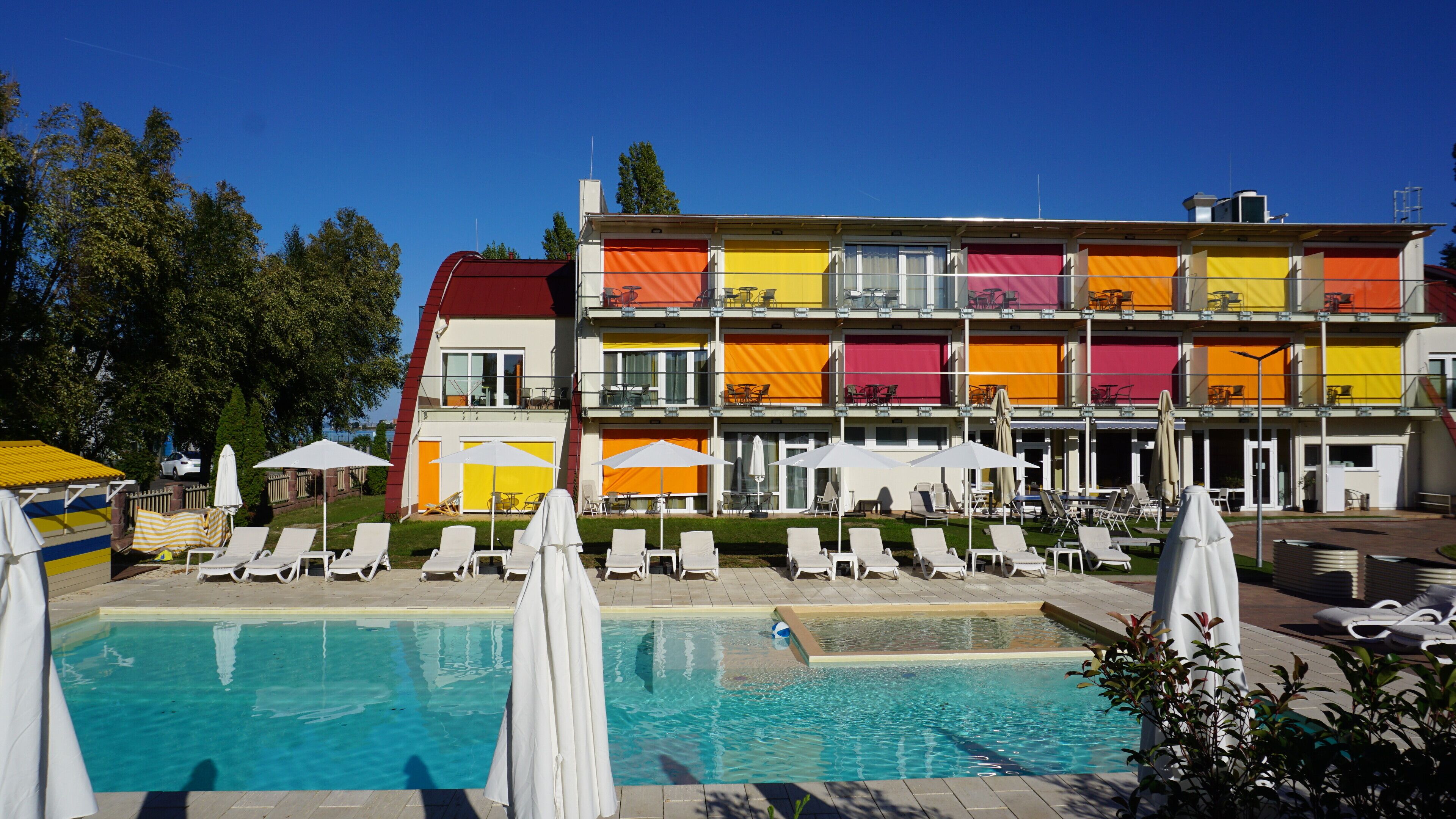 Un hôtel doté d’une piscine, de nombreux balcons et d’espaces extérieurs aménagés pour se détendre.