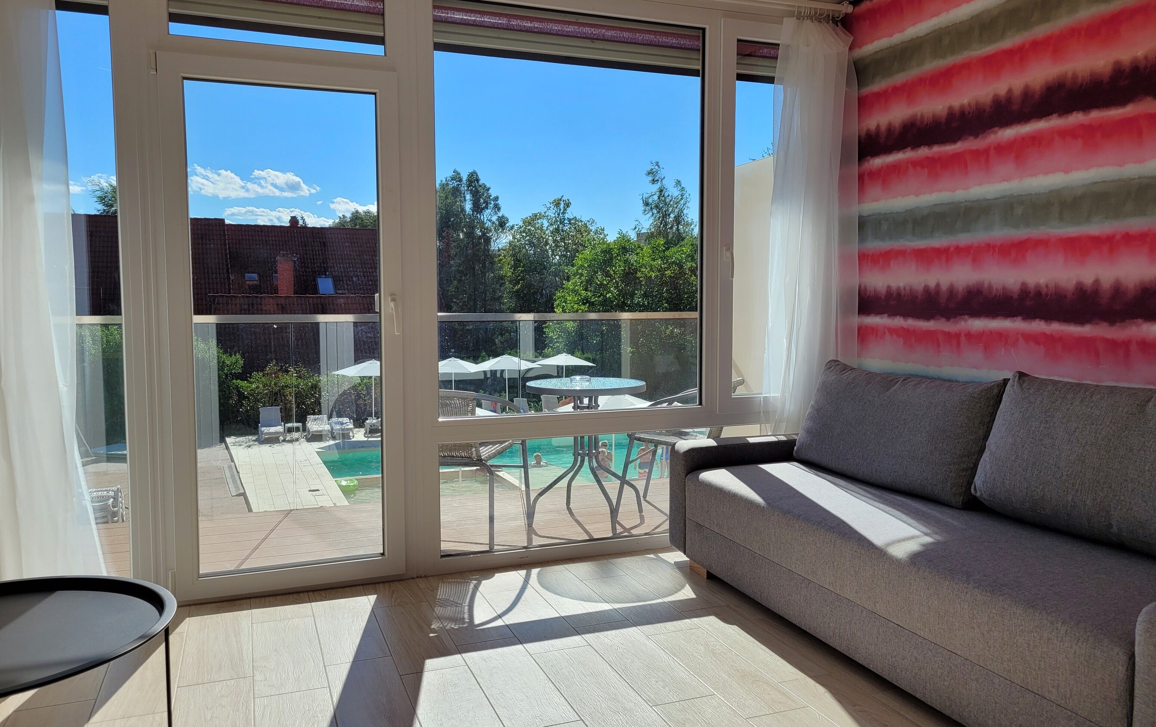 Un balcón con piscina, mobiliario exterior y vistas del entorno.