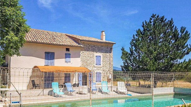 A two-story stone house with a swimming pool, surrounded by a fence and blue lounge chairs. - Cozy home in Malaucène (Malaucène)