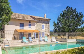 A two-story stone house with a swimming pool, surrounded by a fence and blue lounge chairs. - Cozy home in Malaucène (Malaucène)