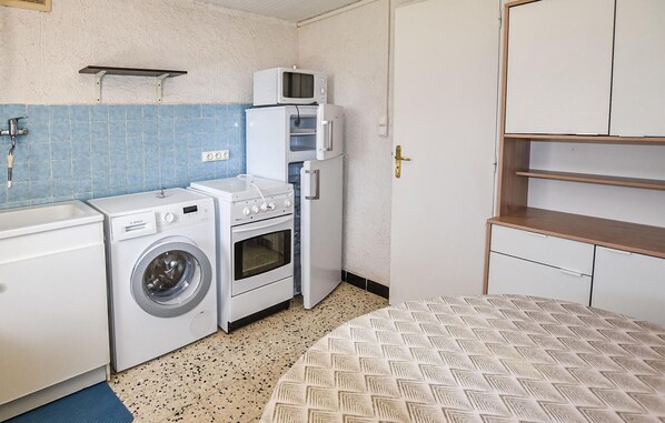 A compact kitchen with a washing machine, a microwave, and a small oven. - Cozy home in Malaucène (Malaucène)