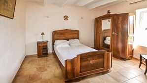 A bedroom with a wooden bed, a nightstand, a wardrobe, and a mirror. - Cozy home in Malaucène (Malaucène)