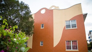 Ein Gebäude mit einer markanten, wellenförmigen Fassade, drei Fenstern und einem flachen Dach.