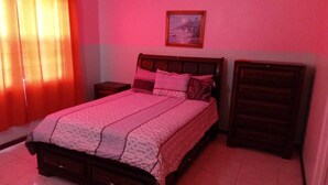 Ein Schlafzimmer mit einem Bett, Nachttischen und einer Kommode.