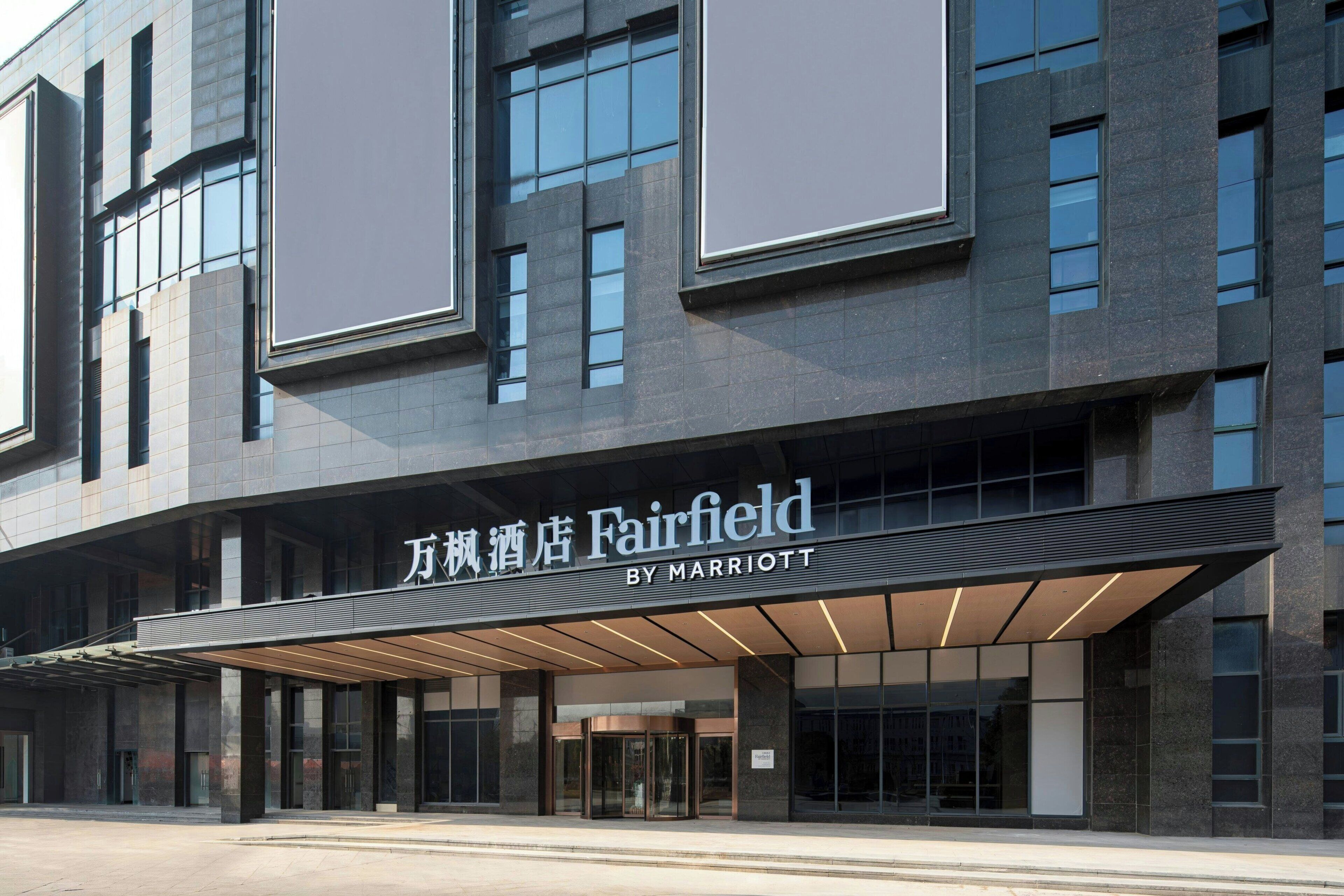 A modern hotel facade with a prominent marquee sign for Fairfield by Marriott.