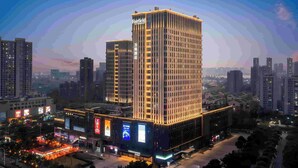 A high-rise hotel with a prominent "Fairfield by Marriott" sign, surrounded by other tall buildings and a bustling urban environment. - Fairfield by Marriott Hangzhou Binjiang Puyan (Hangzhou)