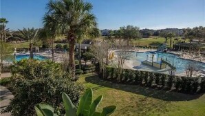 Zona de piscina con palmeras y cielo despejado.