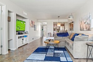 Un salon spacieux doté d’un grand téléviseur à écran plat, d’un canapé confortable et d’une table basse.