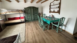 A room with a bunk bed, a dining table with chairs, and a wooden ceiling. - Idyllischer Bauernhof 3 (Wildensbuch)