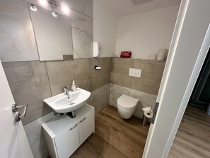 A modern bathroom with a white sink, a toilet, and a mirror. - Idyllischer Bauernhof 3 (Wildensbuch)