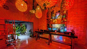 A modern interior with a brick wall, a wooden bench, and hanging decorative lights.