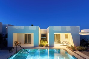 A modern two-story house with a swimming pool, outdoor seating, and a clear sky. - Nous Santorini (Santorini)