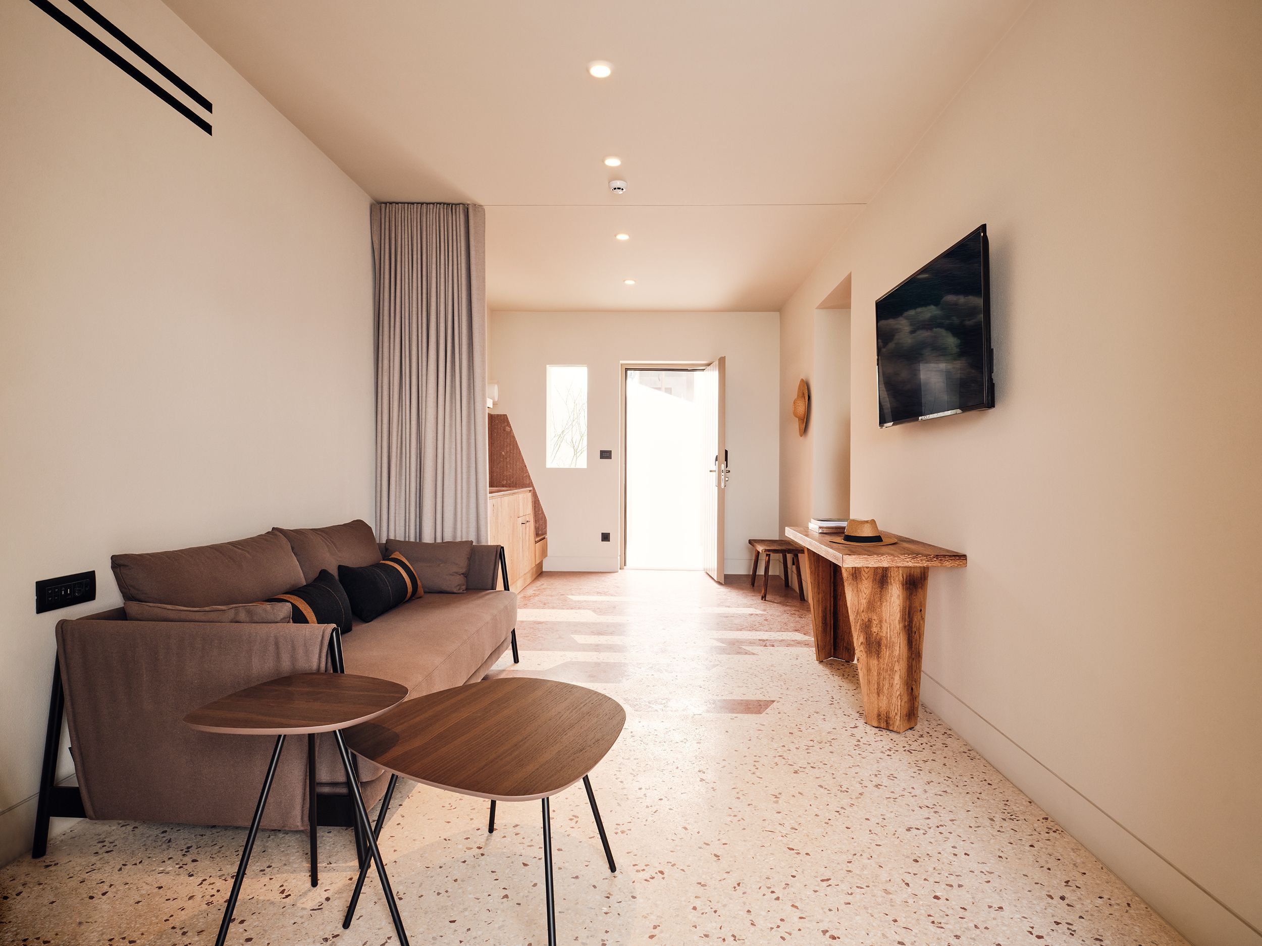 A modern living room with a sofa, coffee table, and a wooden side table.