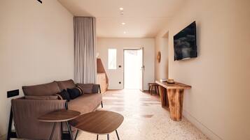 A modern living room with a sofa, coffee table, and a wooden side table.