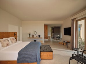 Habitación de hotel moderna con una cama grande, una mesita, un televisor y vistas al exterior.