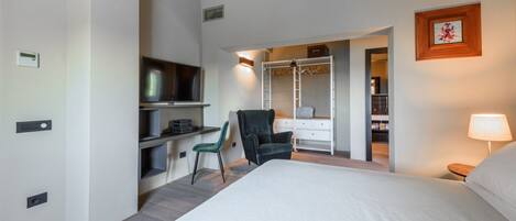 Un dormitorio con cama, escritorio, silla, armario y televisor.